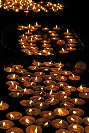 many lit candles in the Church in Rome