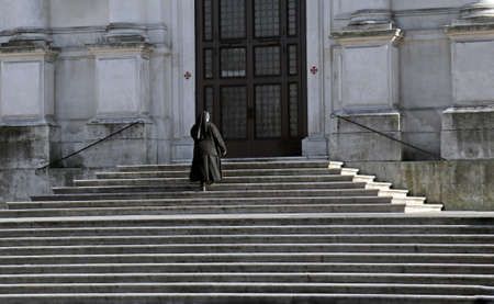 nun who climbs the stairs of the Cathedralの写真素材