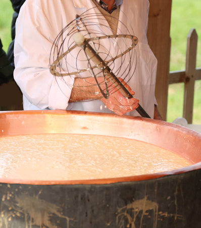 copper pot with boiling milk for making cheese in the mountain dairy