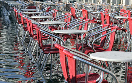 Venice, chairs and tables with water at high tideの写真素材