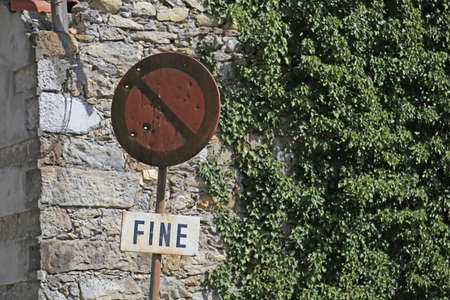 rusty no-parking road sign with written FINE in Italianの写真素材