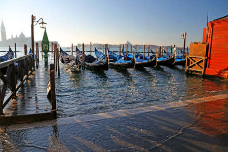 many gondolas in Venice in Italy during high tideの写真素材