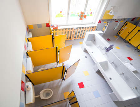 kindergarten bathroom with washbasins and cabins with fisheye lensの写真素材