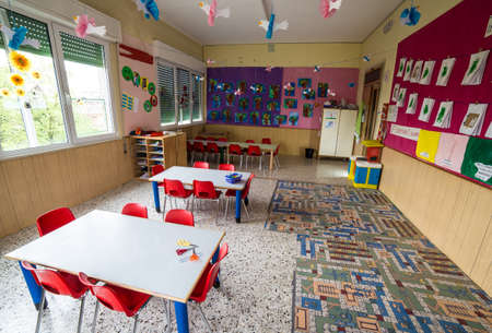In a nursery class with tables and small red chairs for childrenの写真素材