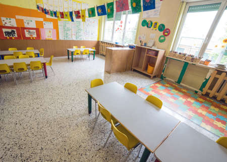 classromm of kindergarten with tables and small yellow chairs for childrenの写真素材