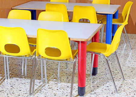 Classroom with yellow chairs and tables in the kindergartenの写真素材