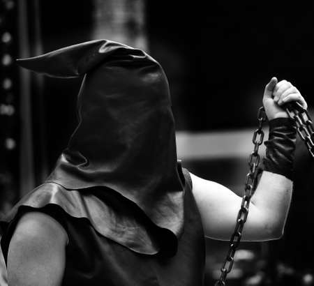 executioner with black hood on his head and the chain with the sentenced to deathの写真素材