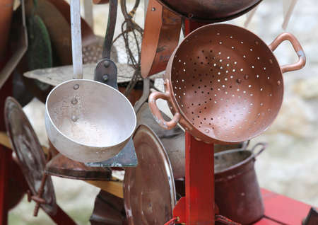 old collander and other old copper objects in cart for sale at flea marketの写真素材
