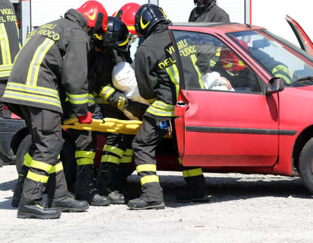 firefighters in action and pull the injured from the carの写真素材