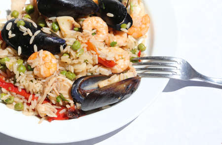 paella rice dish with mussels, shrimp and green peas at fish restaurantの写真素材