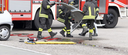 fireman in action during a road accident with car parts and the firetruck