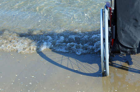 shadow of a wheelchair in the sand on the seashore in summerの写真素材