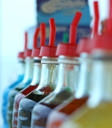 many bottles of colored syrup for preparing ice creams in summerの写真素材