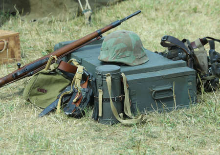 helmet of soldier uniform with a rifle in the army camp during a war exerciseの写真素材