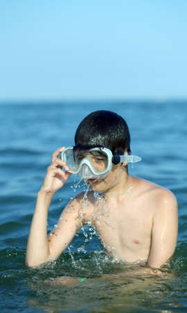 young child swims in the sea with the diving mask in summerの写真素材