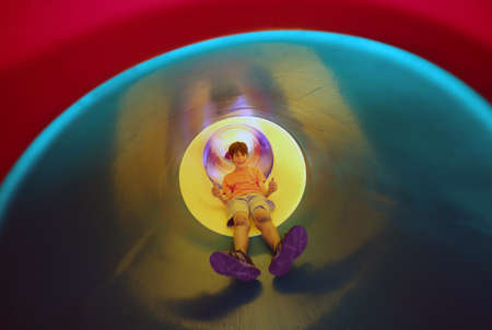 child slides in multicolored tunnel slideの写真素材