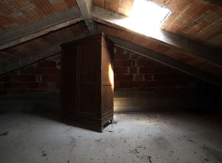 antique wooden wardrobe in the dusty atticの写真素材