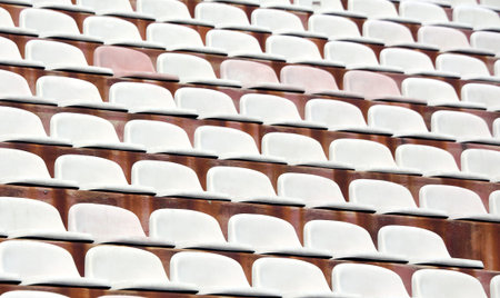 white seats in empty stands of a modern Stadium before the sporting eventsの写真素材