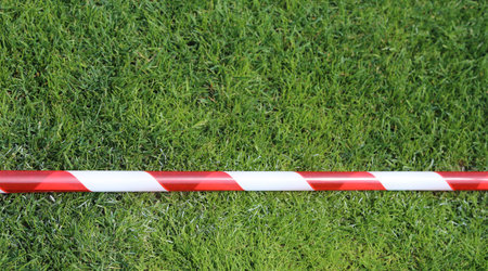 red and white warning tape on the grass of the stadium after the sports event