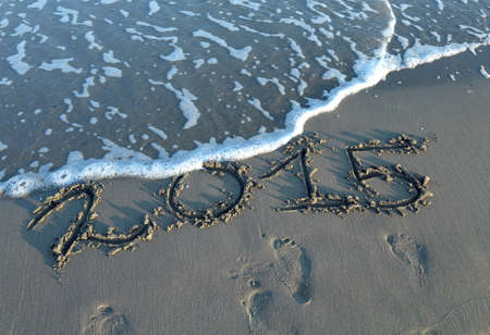 written 2015 year in the sand of the sea with wavesの写真素材