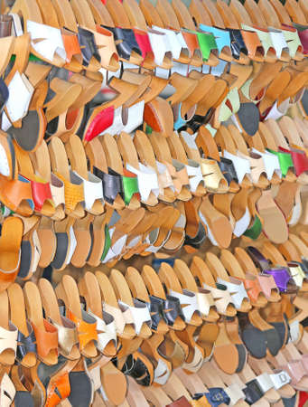 Craft store with many wooden shoes and colored leather hanging from the standの写真素材