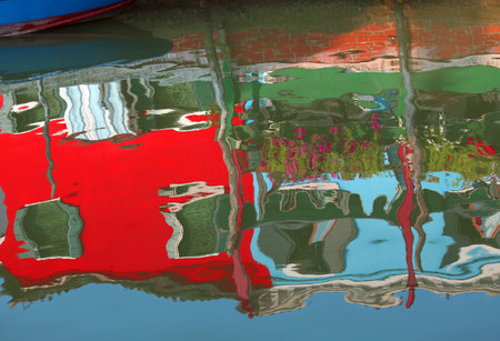 Colourfully painted houses on Burano and reflection on the waterの写真素材