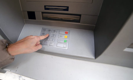 hand enter the secret code in the numeric keypad of the ATM to withdraw money