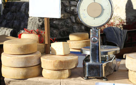 bench of cheese and a balance in the local marketの写真素材