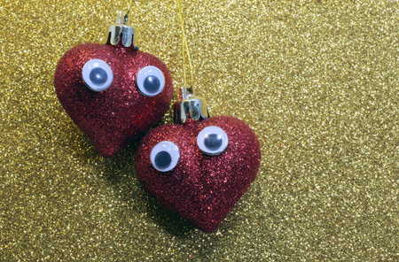 two red hearts in love with great eyes in the golden backgroundの写真素材