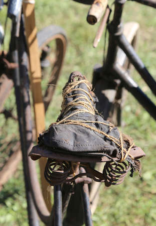 historic old bicycle destroyed with the saddle stitched with twineの写真素材