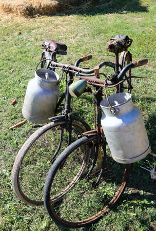 two ancient bicycles for the transport of milk in the bin of aluminumの写真素材