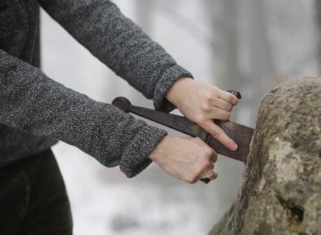 Hand of the valiant knight tries to remove the magical Excalibur sword in the stone