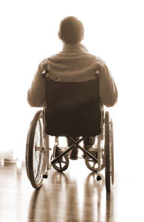 disabled sitting in a wheelchair in the room near the windowの写真素材
