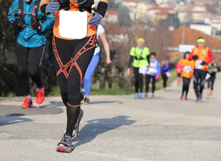 many people run on asphalt road uphill while running outdoors