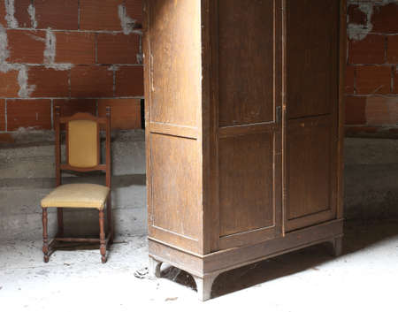 wooden wardrobe in the dusty attic and a chairの写真素材