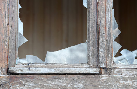 fragments of broken glass of a window in an abandoned house