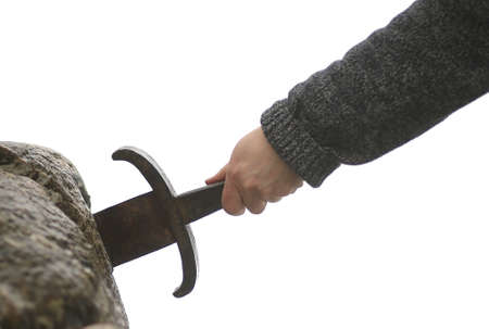 Hand of the valiant knight tries to remove the magical Excalibur sword in the stoneの写真素材