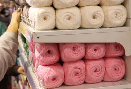 many balls of wool for sale on the shelf in the shop of importers of fabrics and woolの写真素材