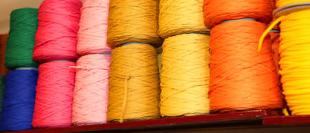 colored spools of thread and balls of wool for sale in the shop for tailorsの写真素材