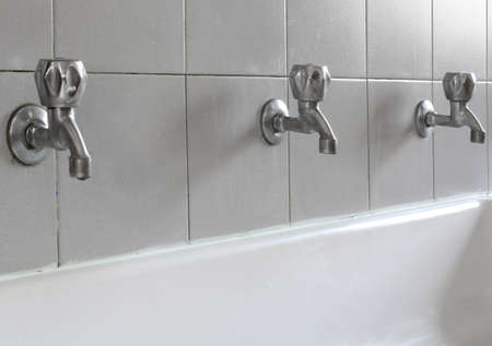 many steel taps in the bathroom of kindergartenの写真素材