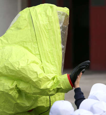 man with yellow protective gear greets with handの写真素材