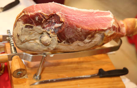 wooden cutting board with the tasty raw ham in the Delicatessen in Italy in the region of Emilia Romagnaの写真素材