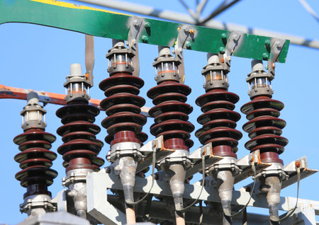 big copper busbar with high-voltage cables and insultators in an electric power plant