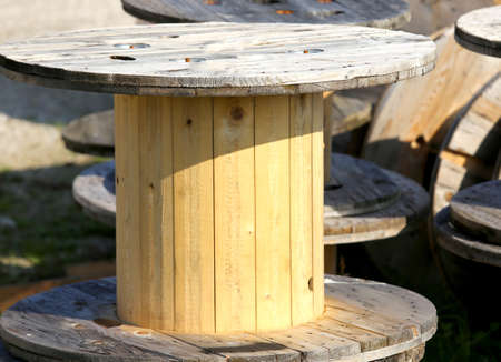 big wooden spools of electric cables in a landfill of recyclable materialsの写真素材
