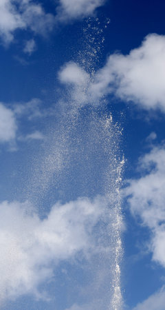 high water jet and the background of the blue sky with white clouds