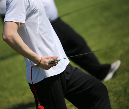 Tai Chi martial arts young athlete expert makes motions with sharp sword