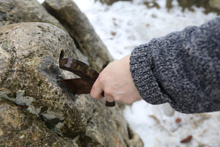 Hand of the valiant knight tries to remove the magical Excalibur sword in the stone