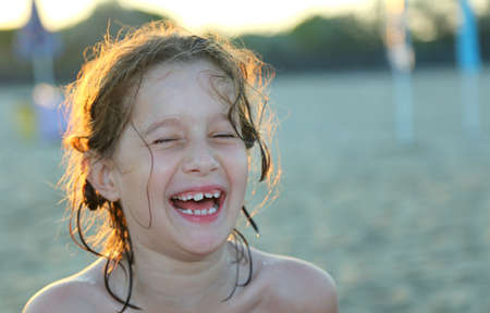 smiling and pretty little girl on the Sea Beach at sunsetの写真素材
