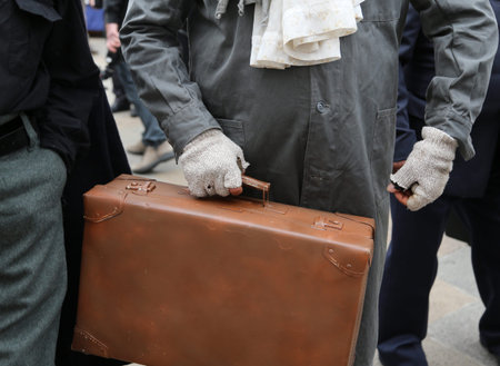 immigrant with old leather suitcase during the trip abroad in the field of humanitarian refugee receptionの写真素材