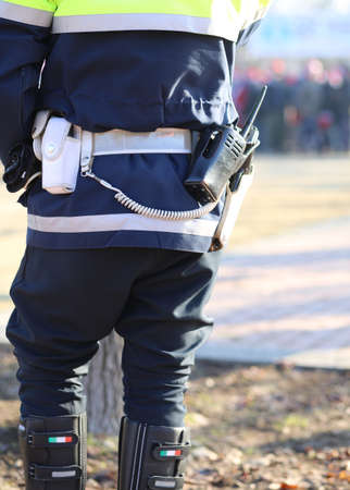 italian policeman in uniform with a radio transmitter and gun during a demonstration of the protestersの写真素材